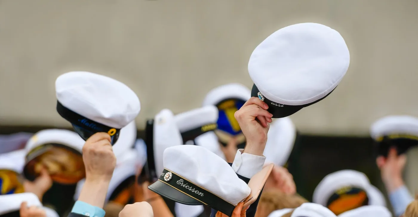 Två studentmössor med broderade namn, närbild